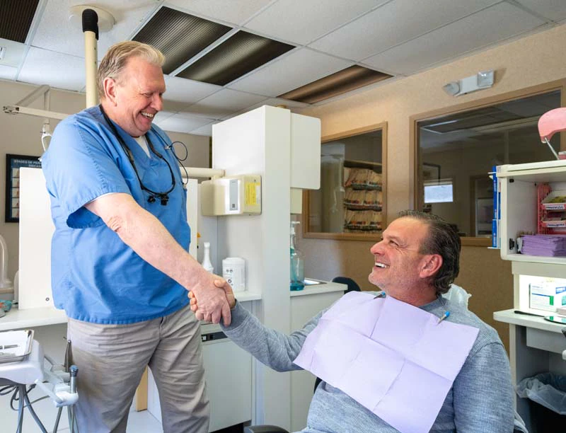 Dr. Kevin Welch shaking the hand of a male patient in the exam at Family Dental Practice in Kokomo IN.
