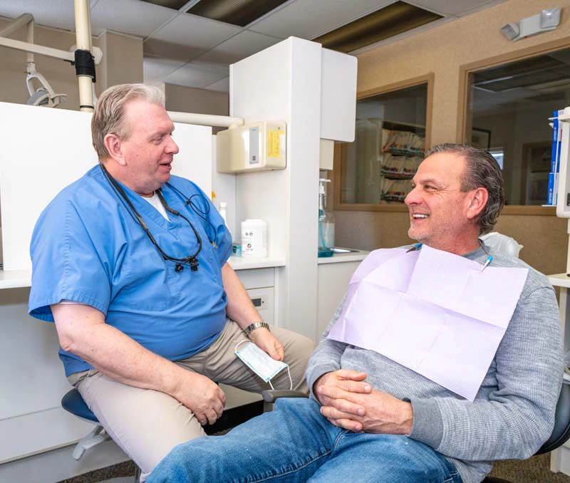 Dr. Kevin Welch and a patient discussing dental veneer options in the exam room at Family Dental Practice in Kokomo IN.